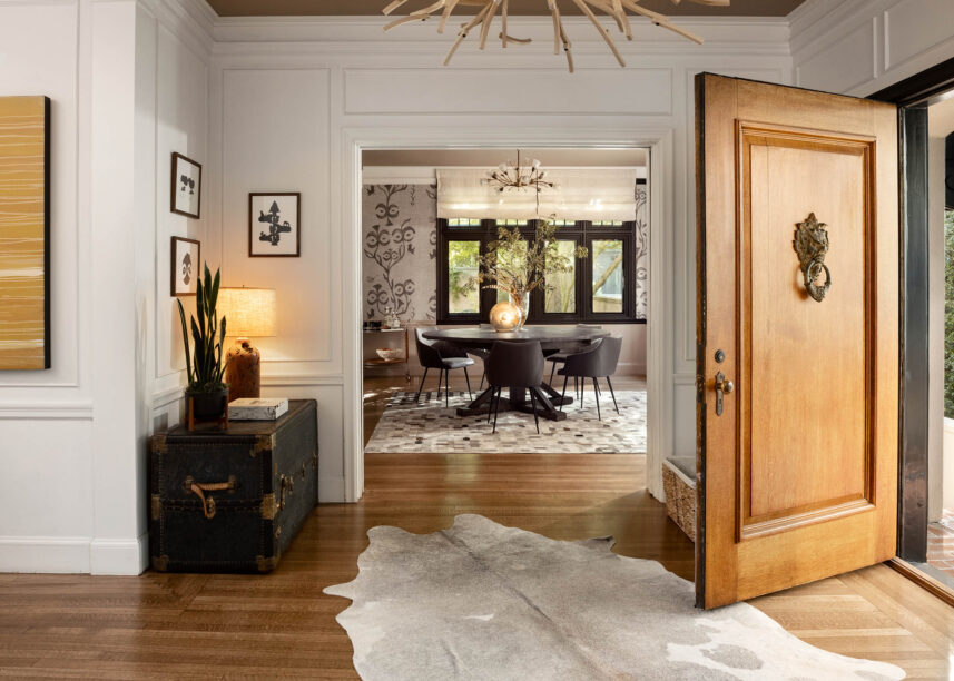 open foyer, cowhide rug, grasscloth wallpaper, black dining table,
