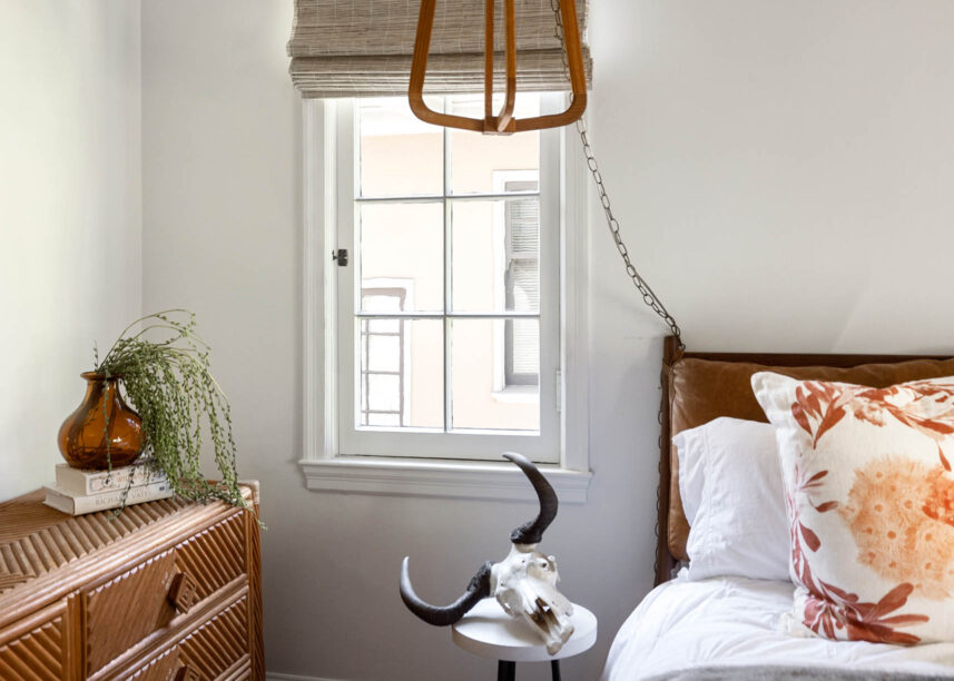 bright and airy bedroom, wooden pendant light, bull skull, house plant